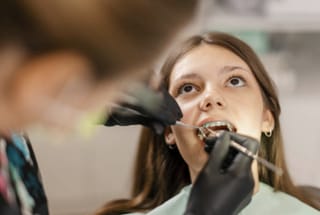 An orthodontic patient receiving treatment on her fixed braces