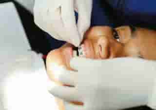 An orthodontist inspects fixed metal braces