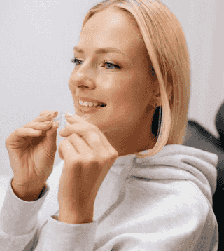 Adult invisalign patient holds her clear aligners